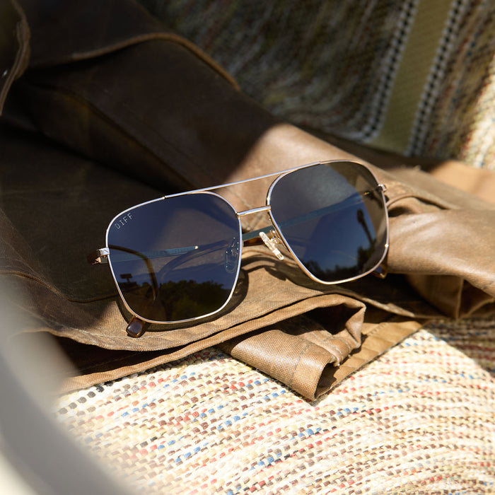 flat lay in a car diff eyewear jonas aviator prescription sunglasses with a gold frame and g15 lenses front view