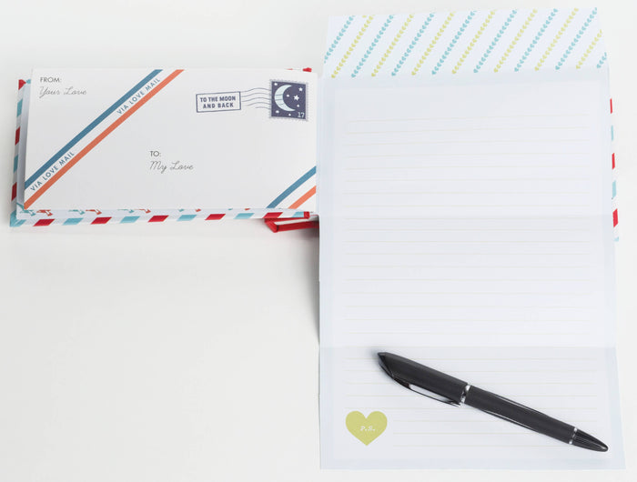 Two stationery items with decorative envelopes and a pen on a white background