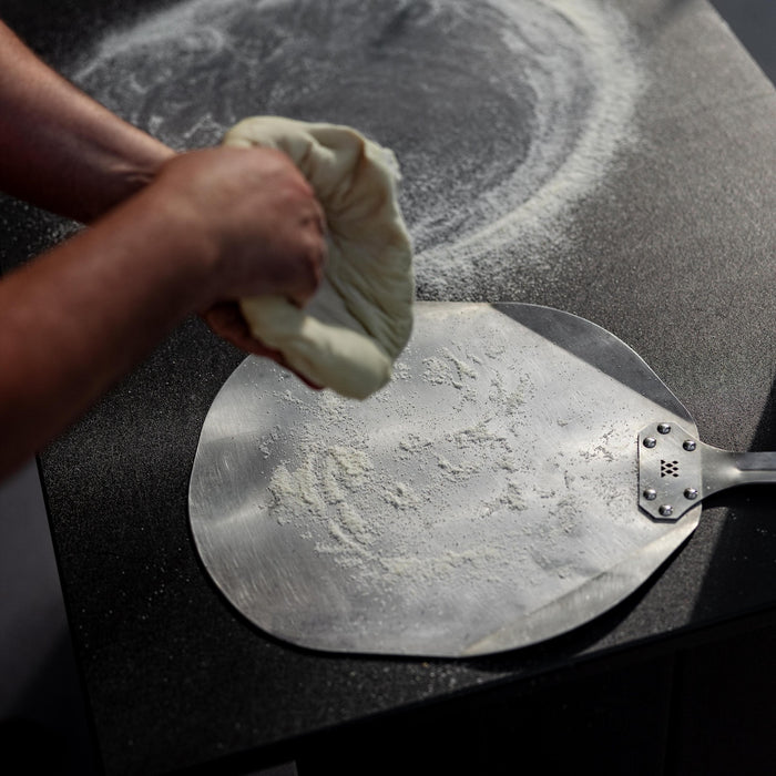 This is an image of dough being prepared on a Breeo Pizza Peel
