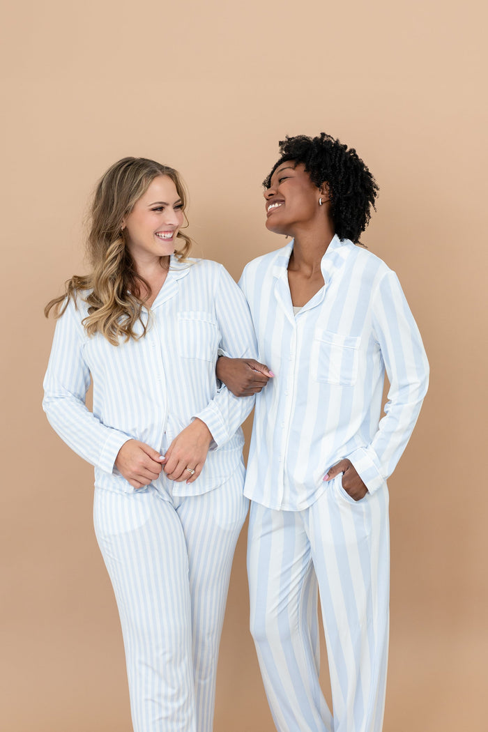 Two smiling female models standing side by side with their arms locked wearing the Long-Sleeved Women's Pajama Set in Small Mist Stripe and Big Mist Stripe