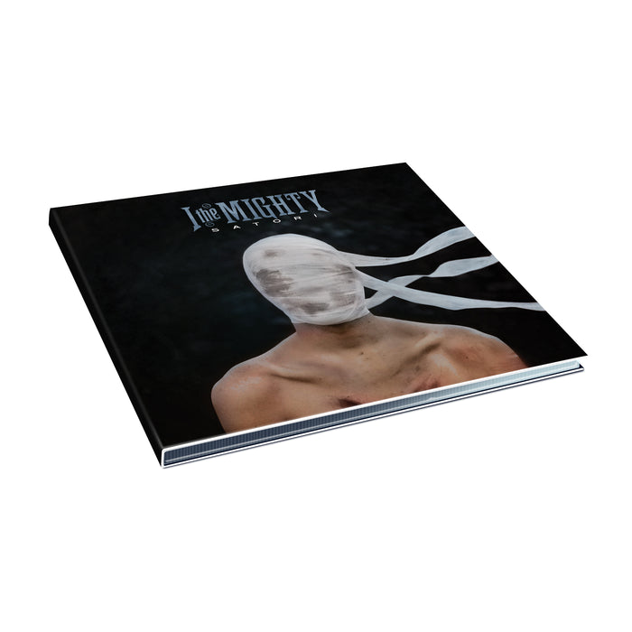 A square album cover from I The Mighty shows a shirtless figure with their head wrapped in white bandages, face hidden. Set against a dark background, it features the band name and Satori at the top, making for an intriguing CD release.