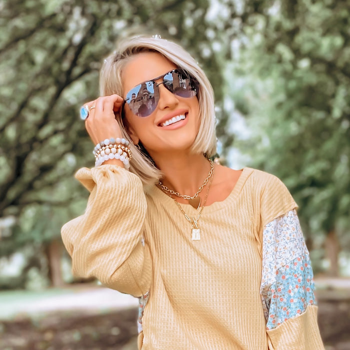 on model - woman wearing gradient aviators and gold jewelry with blond bob cut hair