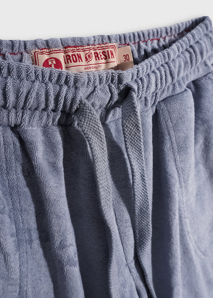 Blue drawstring shorts with an Iron and Resin label, size 30, featuring a textured fabric and elastic waistband.