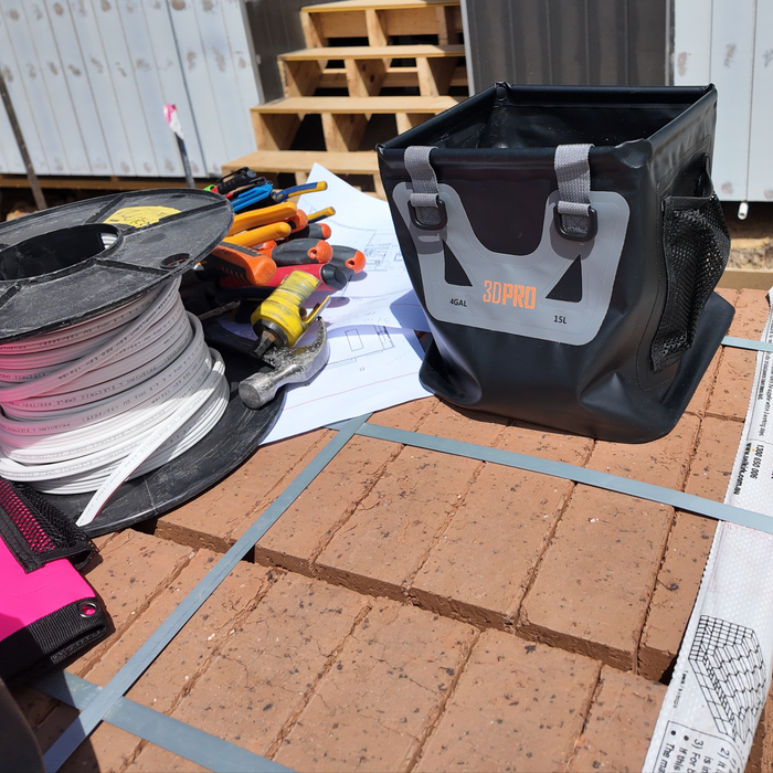 15L/4GAL Pro Square Folding Bucket with '3DPRO' branding on a construction site with tools and materials.