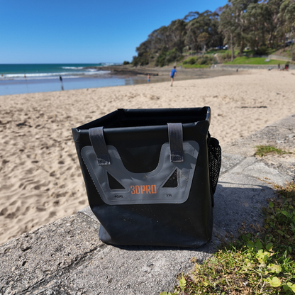 15L/4GAL Pro Square Folding Bucket with '3DPRO' branding on a stone ledge at a beach.