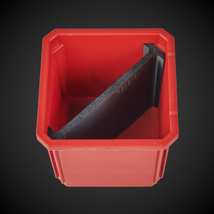 A red plastic bin with a black 2-way standard single bin divider inside it, viewed from a top angle against a dark background.