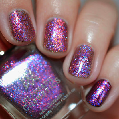 Close-up of nails painted with Amorem Nail Lacquer on fair skin tone. Hand is holding polish bottle.