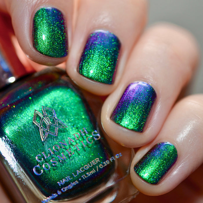 Close-up of nails painted with Anneal Nail Lacquer on fair skin tone. Hand is holding polish bottle.