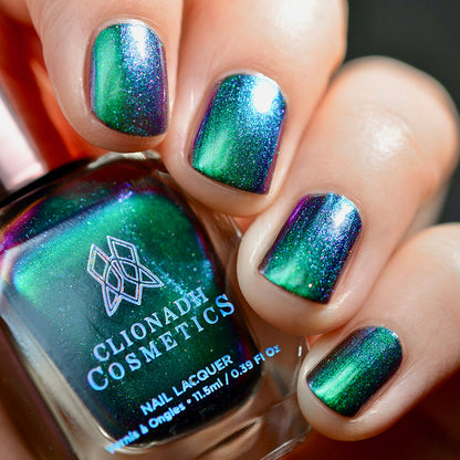 Close-up of nails painted with Anneal Nail Lacquer on fair skin tone. Hand is holding polish bottle.