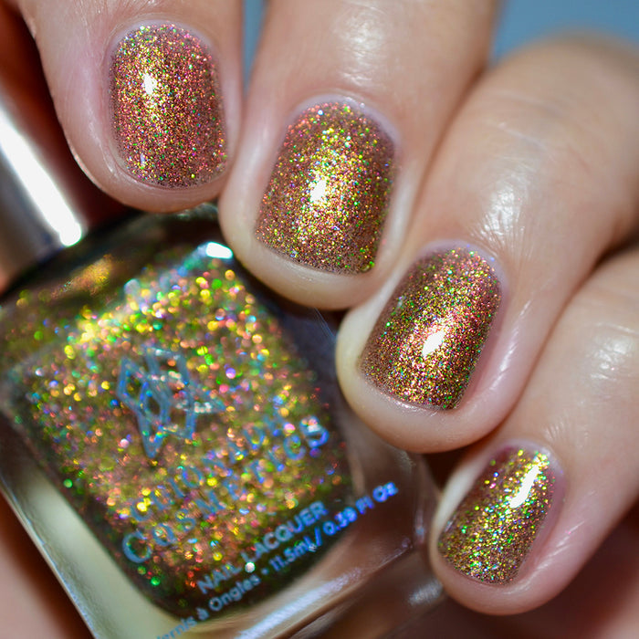 Close-up of nails painted with Apple Picking Nail Lacquer on fair skin tone. Hand is holding polish bottle.