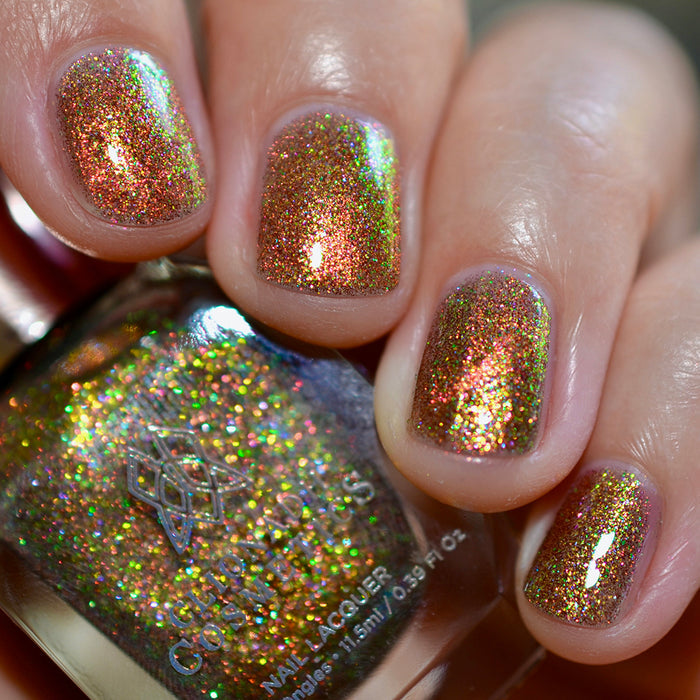 Close-up of nails painted with Apple Picking Nail Lacquer on fair skin tone. Hand is holding polish bottle.