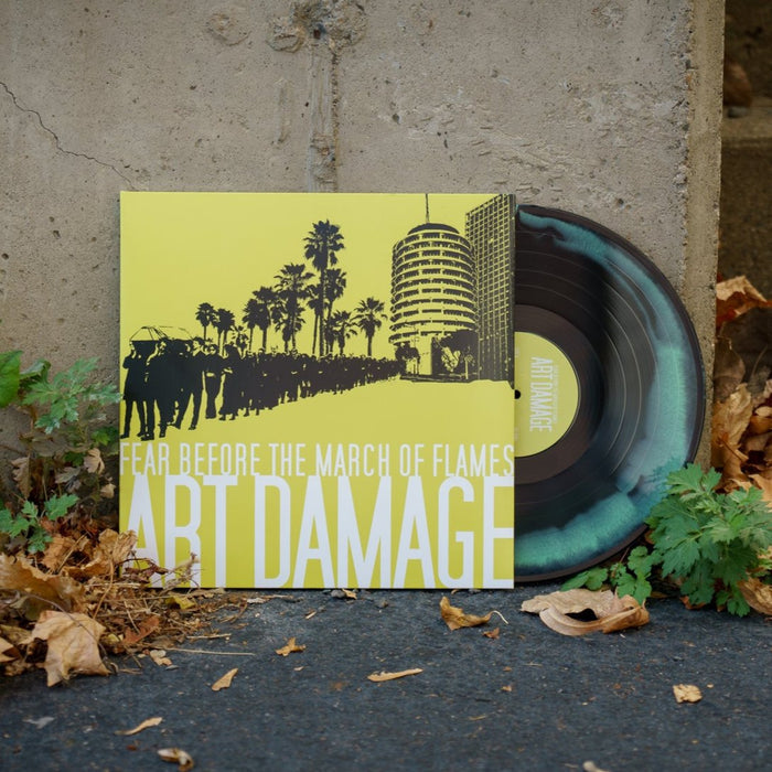 A Black & Mint Green Mixed vinyl by Fear Before rests on the ground near dry leaves and a concrete wall. The album cover reads Fear Before Art Damage in bold yellow and white. Limited to 250 copies.