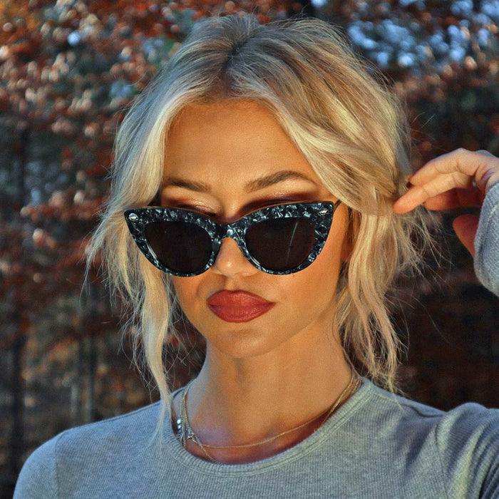 lifestyle - Ashley Smith wearing harry potter x diff eyewear bellatrix cat eye sunglasses with a geo black frame and solid grey lenses front view