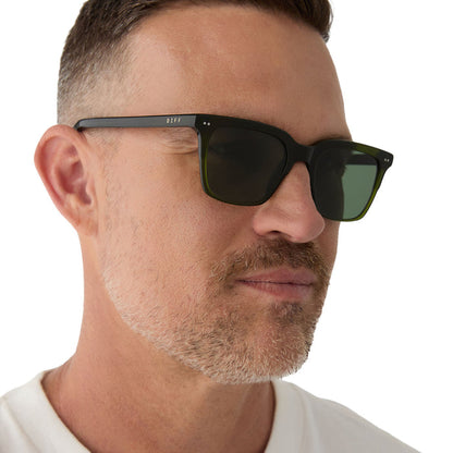 on model - male wearing diff eyewear featuring the billie square sunglasses with a dark olive green crystal frame and g15 polarized lenses angled view