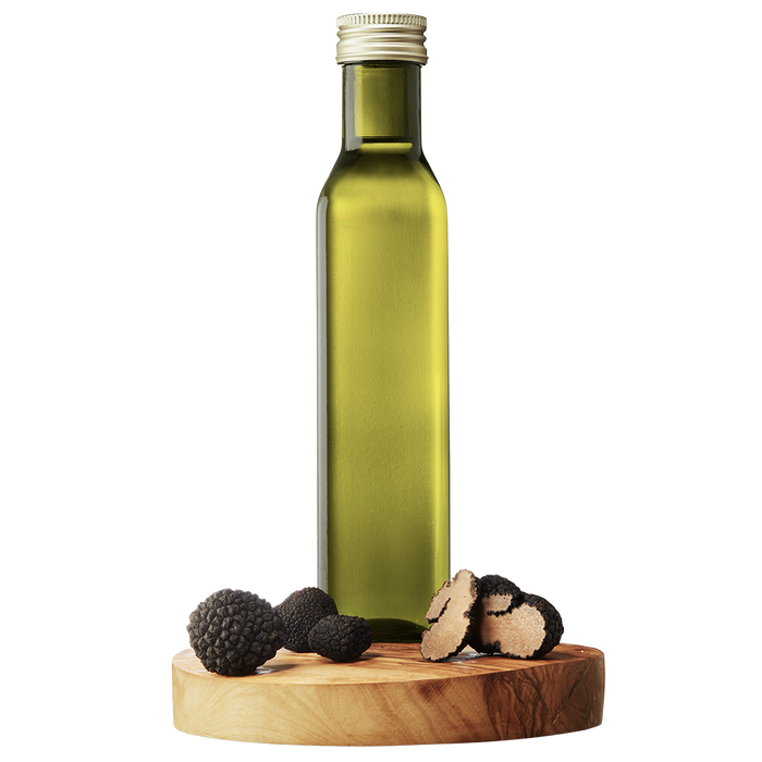 A bottle of Black Truffle Extra Virgin Olive Oil on a wooden platform with whole black truffles beside it.