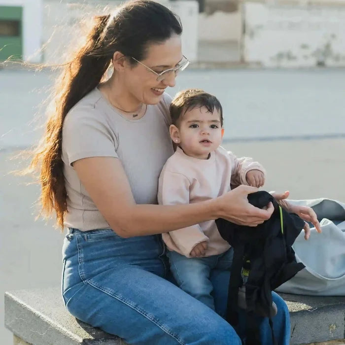 A lightweight, Boba Air Baby Travel Carrier with padded mesh straps, leg openings, adjustable shoulder straps, and an integrated hood. Compact and self-storing, it fits babies 4-24 months (15+ lbs) and children up to 45 lbs, Black