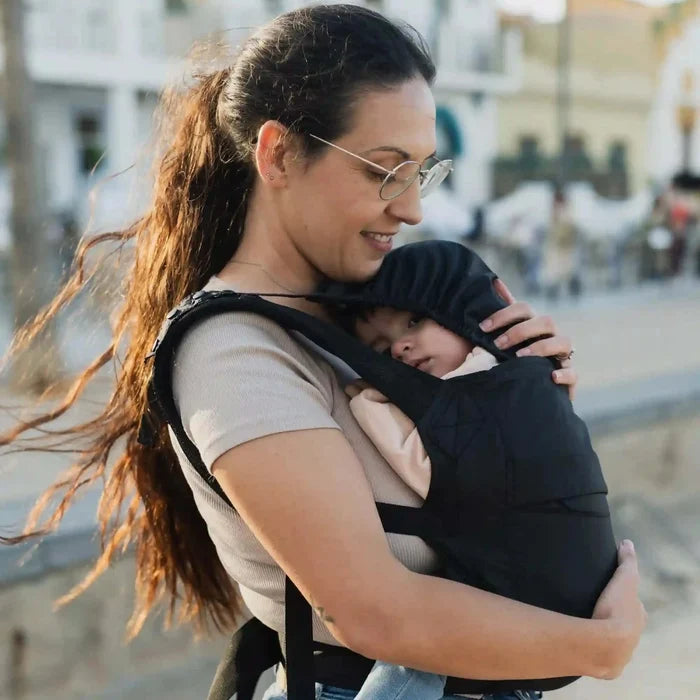 A lightweight, Boba Air Baby Travel Carrier with padded mesh straps, leg openings, adjustable shoulder straps, and an integrated hood. Compact and self-storing, it fits babies 4-24 months (15+ lbs) and children up to 45 lbs, Black