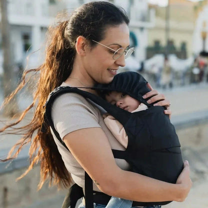 A lightweight, Boba Air Baby Travel Carrier with padded mesh straps, leg openings, adjustable shoulder straps, and an integrated hood. Compact and self-storing, it fits babies 4-24 months (15+ lbs) and children up to 45 lbs, Black