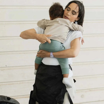 A lightweight, Boba Air Baby Travel Carrier with padded mesh straps, leg openings, adjustable shoulder straps, and an integrated hood. Compact and self-storing, it fits babies 4-24 months (15+ lbs) and children up to 45 lbs, Black
