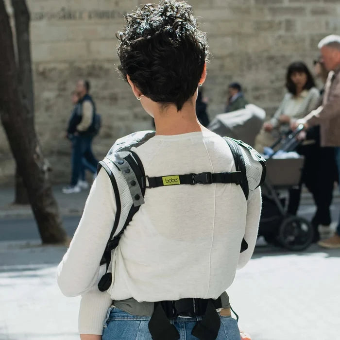 A lightweight, Boba Air Baby Travel Carrier with padded mesh straps, leg openings, adjustable shoulder straps, and an integrated hood. Compact and self-storing, it fits babies 4-24 months (15+ lbs) and children up to 45 lbs, Gray