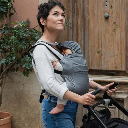 A lightweight, Boba Air Baby Travel Carrier with padded mesh straps, leg openings, adjustable shoulder straps, and an integrated hood. Compact and self-storing, it fits babies 4-24 months (15+ lbs) and children up to 45 lbs, Gray