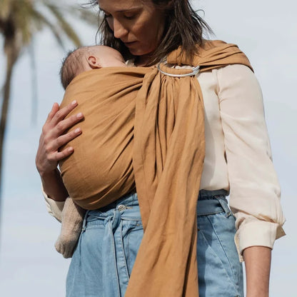 A Boba Ring Sling Baby Carrier made from a unique linen bamboo viscose fabric blend, perfect for all seasons. Lightweight and breathable, it stores compactly, ideal for newborn snuggles to toddler ups and downs (8 - 35Ibs). Rye Brown
