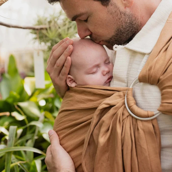 A Boba Ring Sling Baby Carrier made from a unique linen bamboo viscose fabric blend, perfect for all seasons. Lightweight and breathable, it stores compactly, ideal for newborn snuggles to toddler ups and downs (8 - 35Ibs). Rye Brown