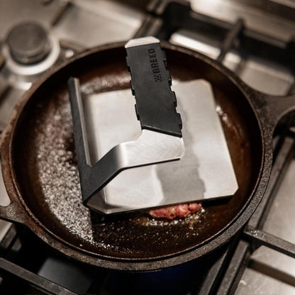This is an image of a smash burger on a skillet pressed with a Breeo Griddle Press