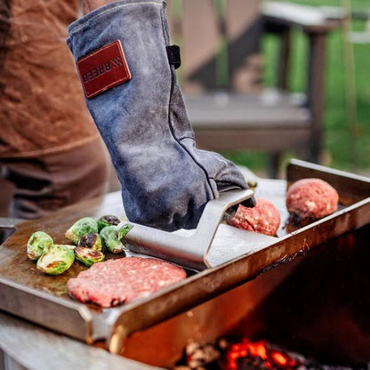 Thisis an image of a man pressing a burger on the Flat top using a Griddle Press