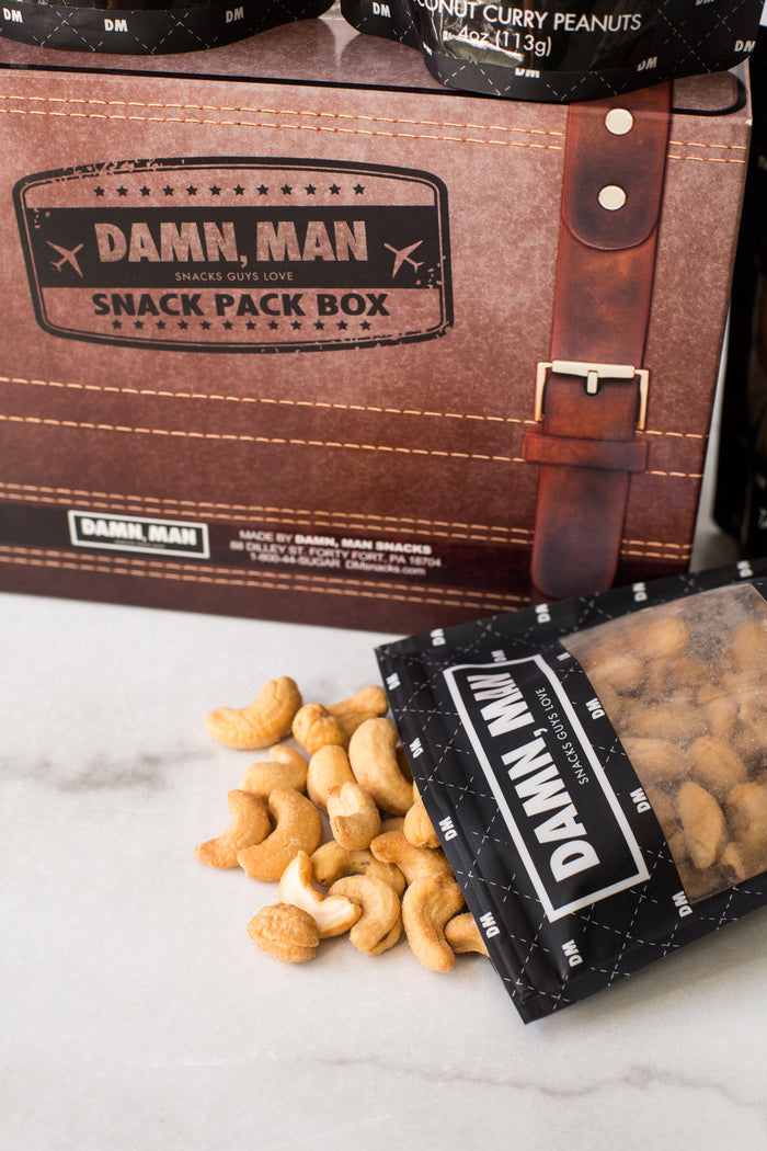 Damn, Man Snacks 4-Pack Box with Mixed Nuts spilling from a packet, perfect for customized snack adventures.