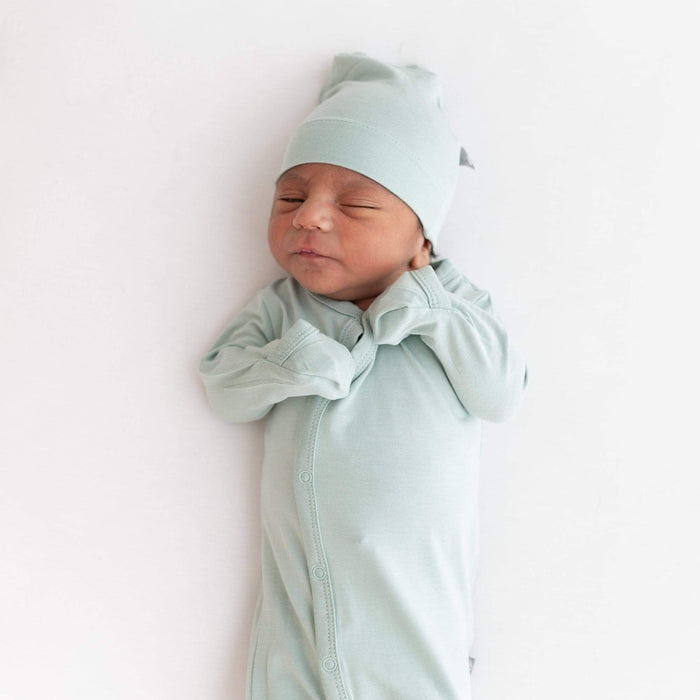 Close up of newborn wearing Kyte Baby Snap Bundler in Sage with fold-over cuffs being used