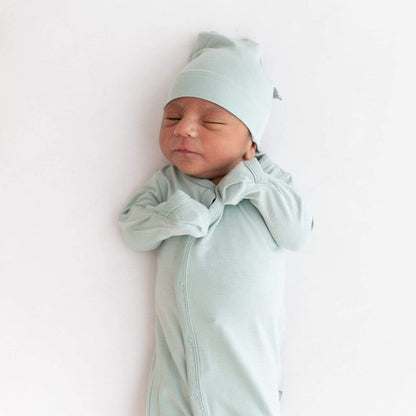 Close up of newborn wearing Kyte Baby Snap Bundler in Sage with fold-over cuffs being used