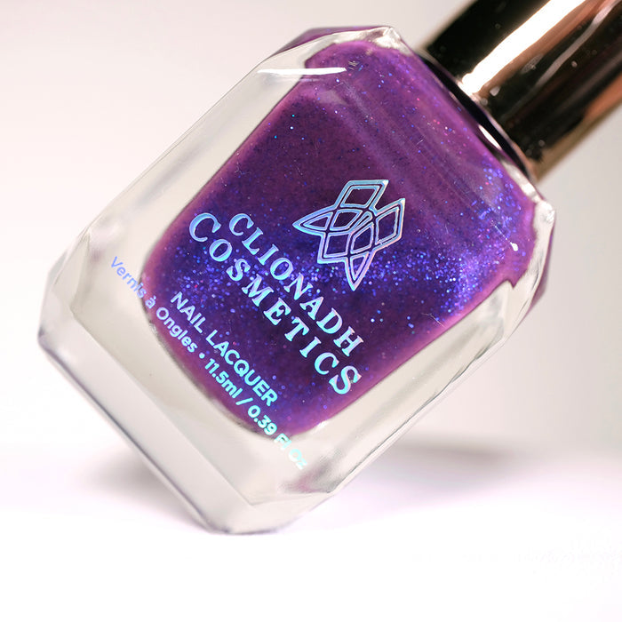 Angled, close-up of Butterfly Pea Flower Nail Lacquer bottle on a light background.