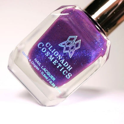 Angled, close-up of Butterfly Pea Flower Nail Lacquer bottle on a light background.