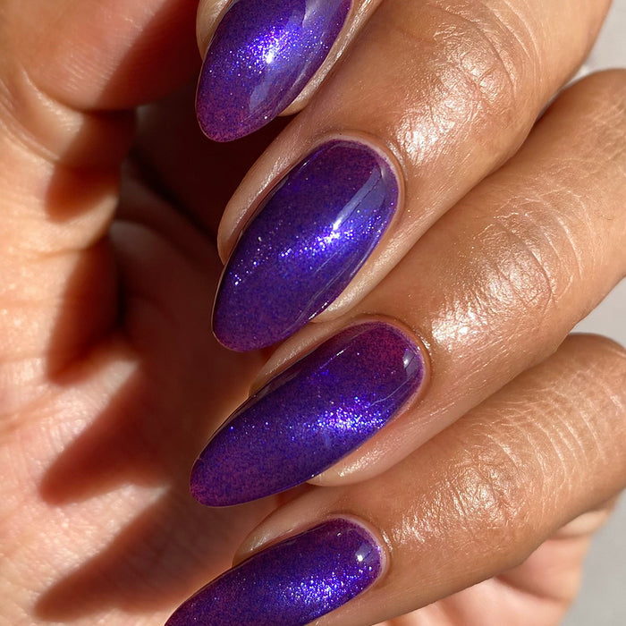 Close-up of nails painted with Butterfly Pea Flower Nail Lacquer on medium skin tone.