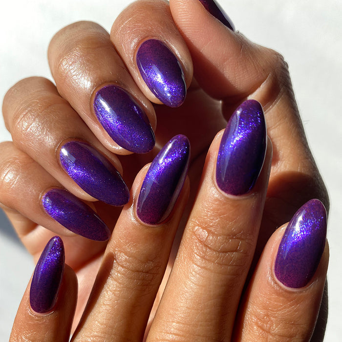 Nails painted with Butterfly Pea Flower Nail Lacquer on medium skin tone.