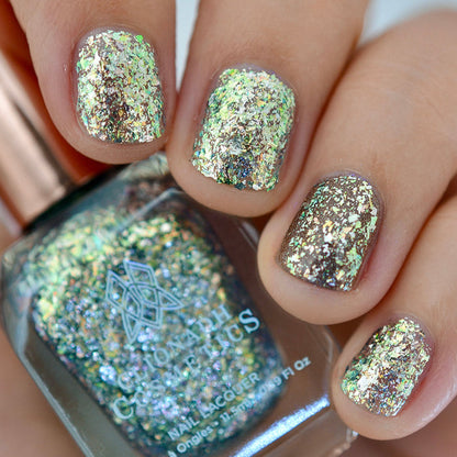 Close-up of nails painted with Catacomb Nail Lacquer on fair skin tone. Hand is holding polish bottle.