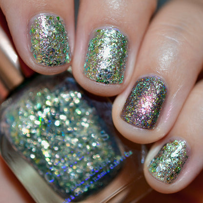 Close-up of nails painted with Catacomb Nail Lacquer on fair skin tone. Hand is holding polish bottle.
