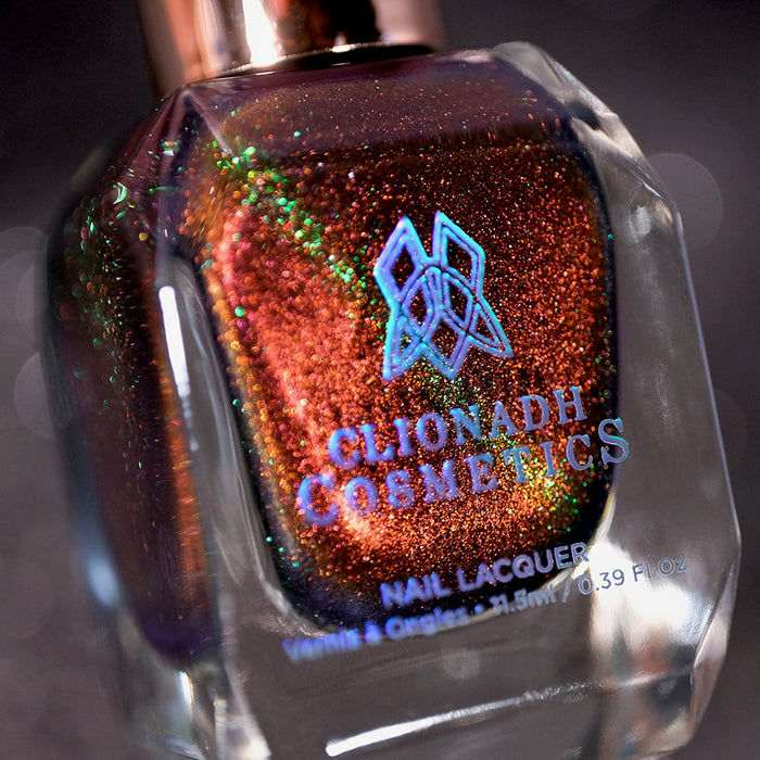 Angled, close-up of Cemetery Nail Lacquer bottle on a black background.