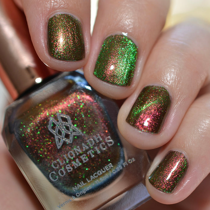 Close-up of nails painted with Cemetery Nail Lacquer on fair skin tone. Hand is holding polish bottle.