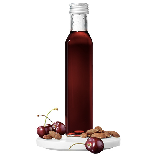 A tall, slender bottle of Cherry Almond Vinegar with a silver cap, accompanied by whole cherries and almonds placed in front.