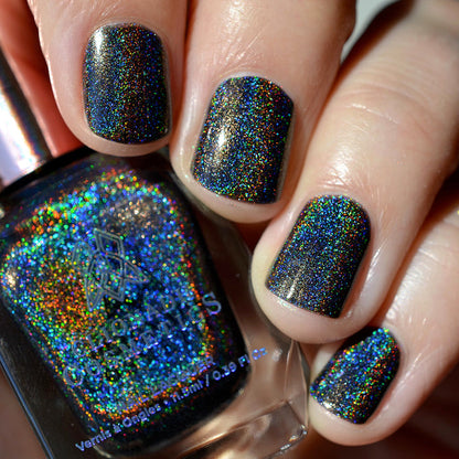 Close-up of nails painted with Chocholo Chips Nail Lacquer on fair skin tone. Hand is holding polish bottle.
