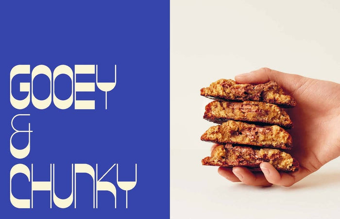 Hand holding a stack of cookies with 'Gooey & Chunky' text on a blue and white background