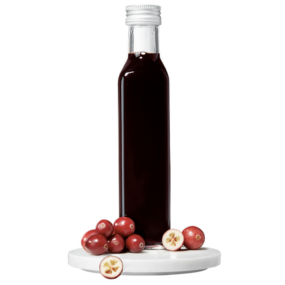 A bottle of Cranberry Balsamic Vinegar with fresh cranberries in front of it.