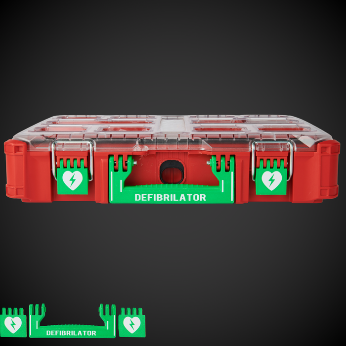 A red and clear Defibrillator kit container with green handles and white text labels, designed to fit into a Milwaukee Packout stack.