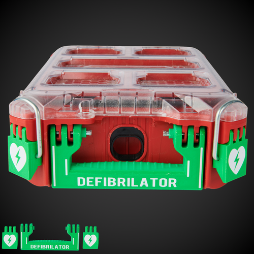 A green and red defibrillator case with a clear top, featuring a white text label that reads 'DEFIBRILLATOR' and heart symbols on the latches.