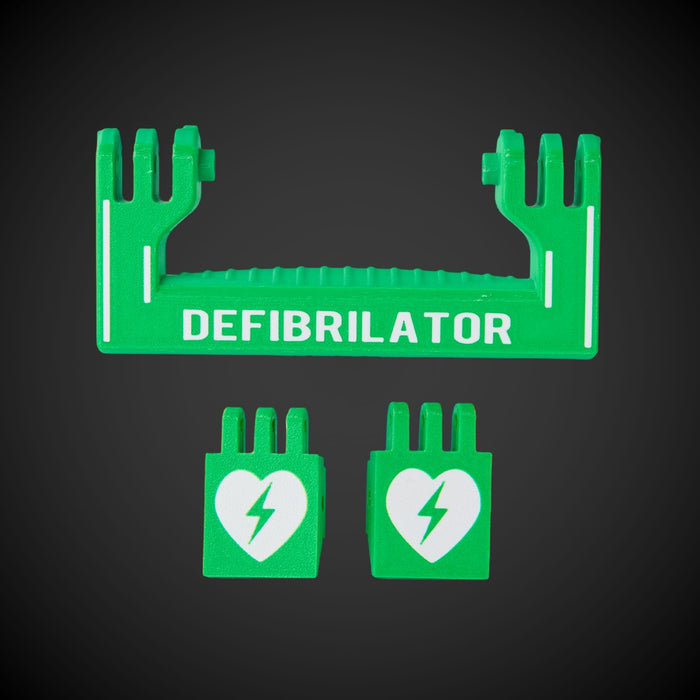 A set of green defibrillator components with white text and a heart symbol on a dark background. Includes a handle and two latches.