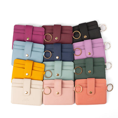 Collection of colorful leather card holders with keychains on a white background