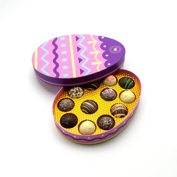 Colorful chocolate truffles in an Easter-themed tin on a white background