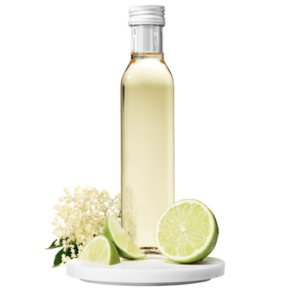A bottle of Elderflower Apple Lime Vinegar with a cap, accompanied by elderflower blossoms and lime slices.